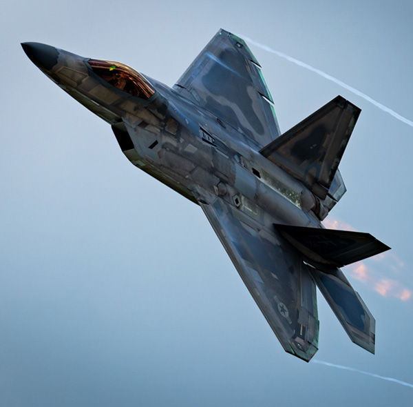 A modern military jet fighter aircraft gliding through an azure sky