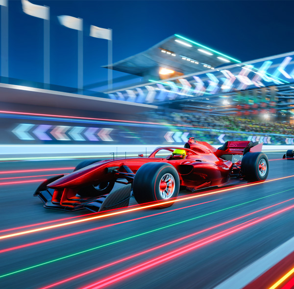 Formula one cars driving fast on a night track 